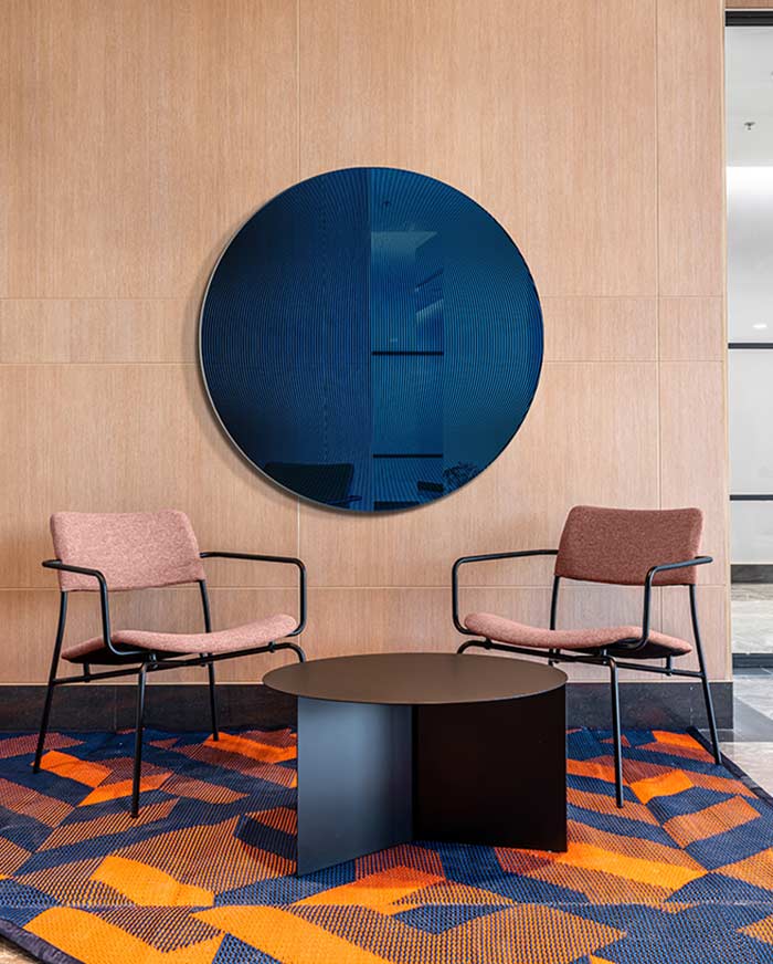 Niebieskie lustro Cosmic Neptune w hotelowym wnętrzu w stylu modern