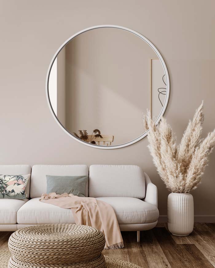 Duże lustro Scandi w białej ramie w salonie urządzonym w skandynawkim stylu. GieraDesign