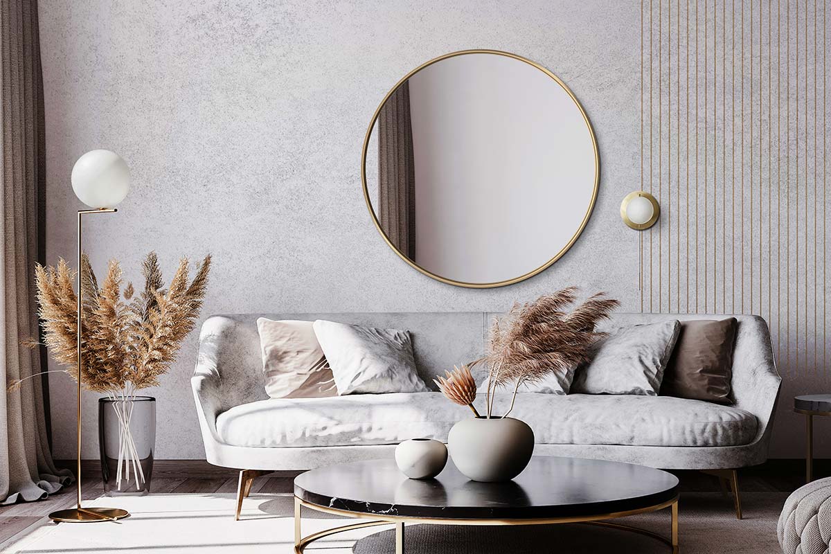 Duże okrągłe lustro w złotej ramie Scandi Slim zawieszone nad kanapą w salonie modern classic