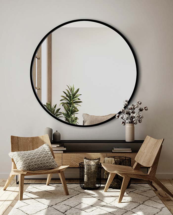 Lustro Scandi czarnej ramie nad komoda w nowoczesnym salonie. GieraDesign